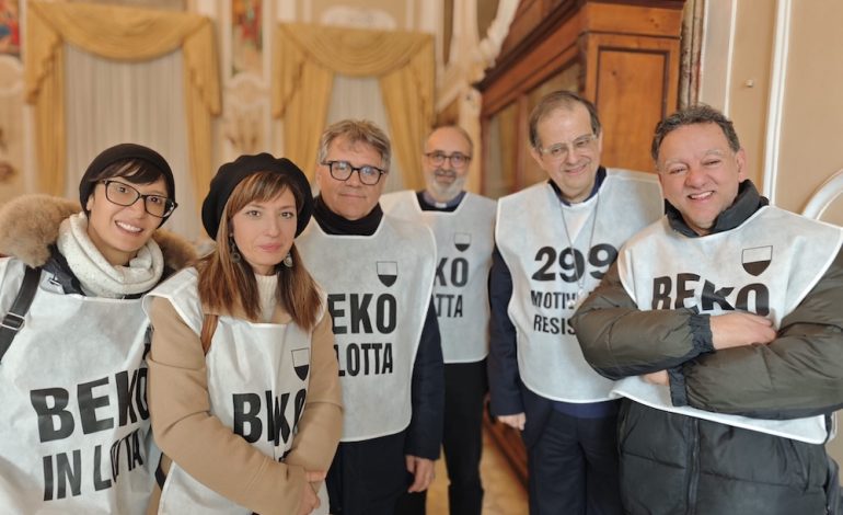 I lavoratori della Beko accolti dal cardinale Lojudice che indossa la pettorina di protesta